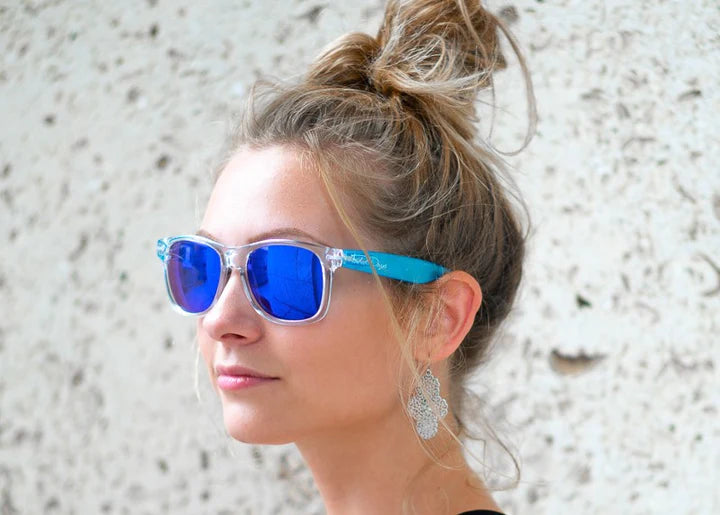 Model wearing Classic 145mm large frame sunglasses in Iceberg – icy clear style and bold blue mirror lenses.