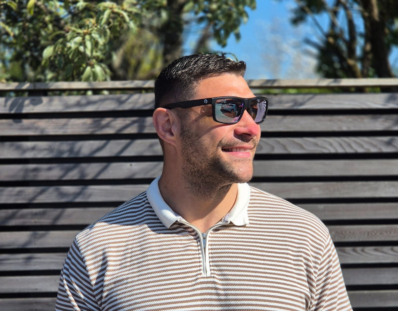 Model wearing Sport 155mm XL polarised sport sunglasses in Black with chrome lenses – bold mirrored style for round faces.