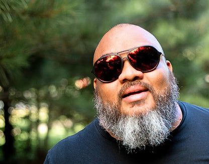 Model wearing XXL aviator sunglasses in Black with red lava lenses – large aviators for men with fiery mirrored lenses.